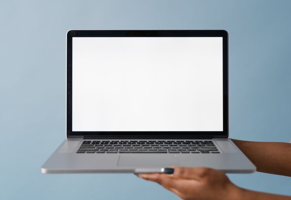 Close-up of a laptop held by a hand, perfect for tech product mockups with blue background