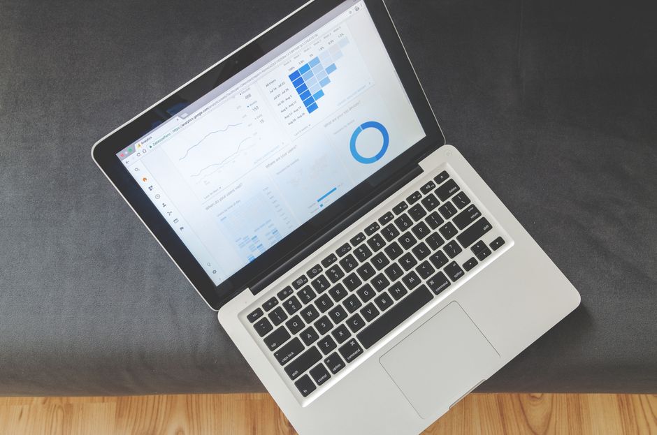 Overhead view of a laptop showing data visualizations and charts on its screen