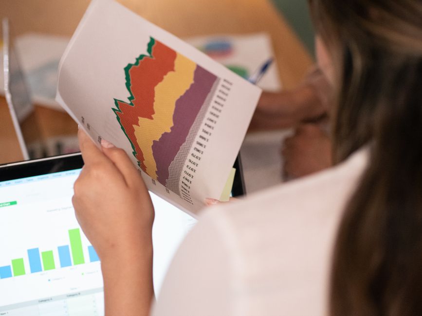 Close-up of a woman analyzing colorful charts and graphs in an office setting