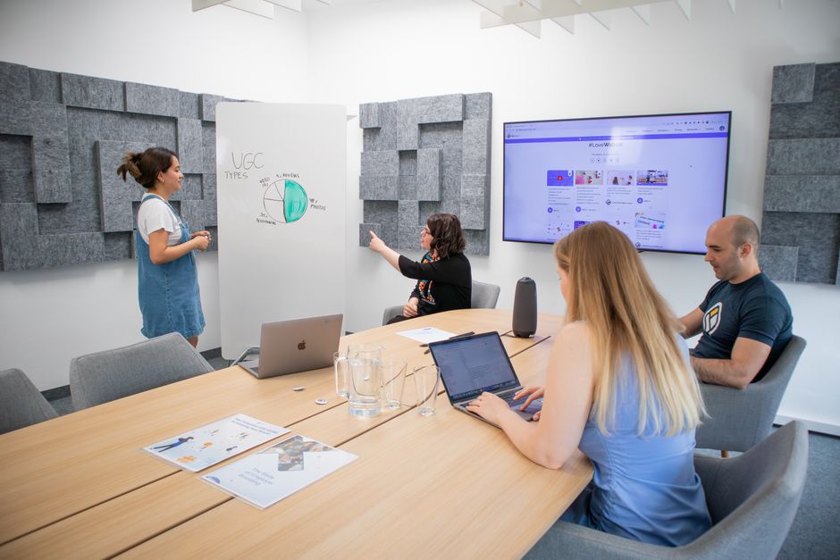 A group of professionals engaged in a team meeting with a presentation in a modern office setting