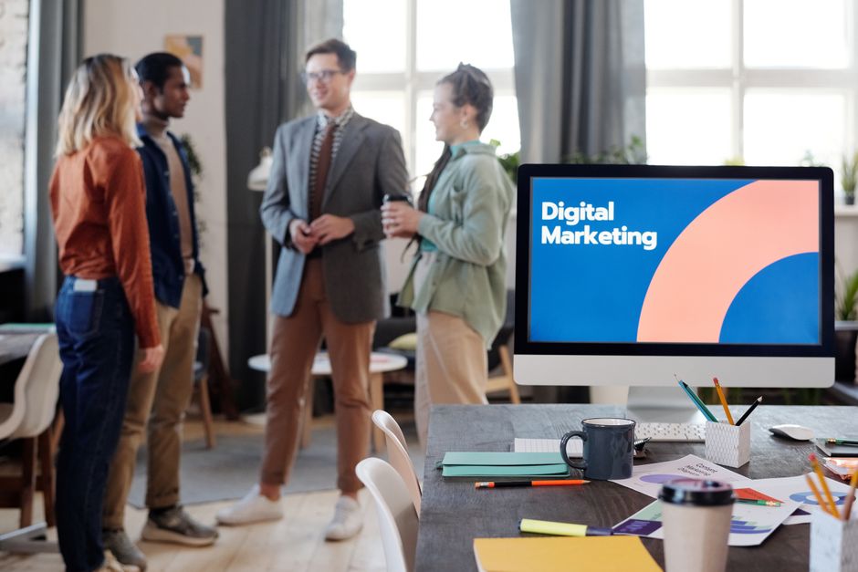 A diverse team collaborates in a modern office setting, discussing digital marketing strategies